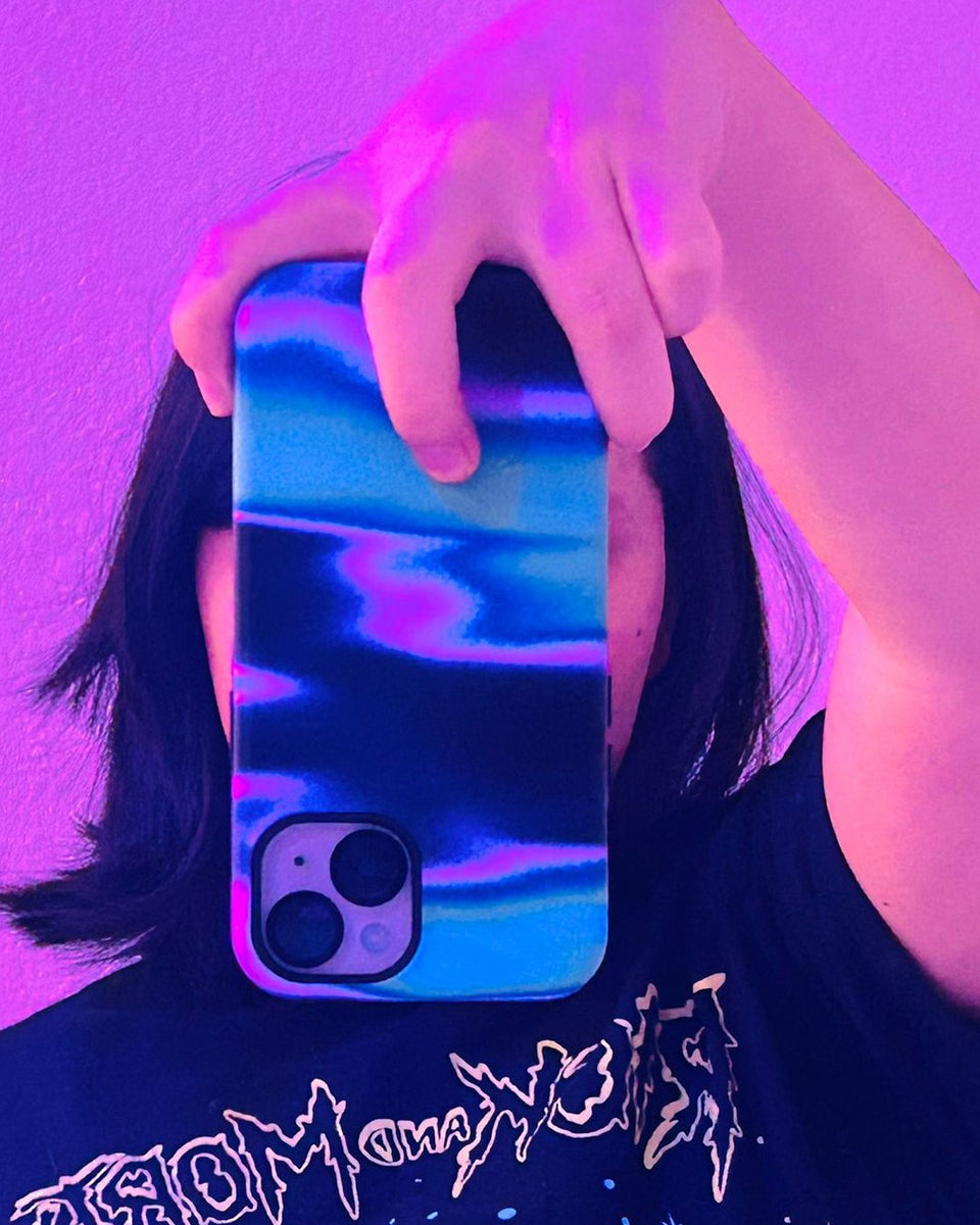 A customer holds up an iPhone in the Lucent case, a glowing pink, violet and blue gradient
