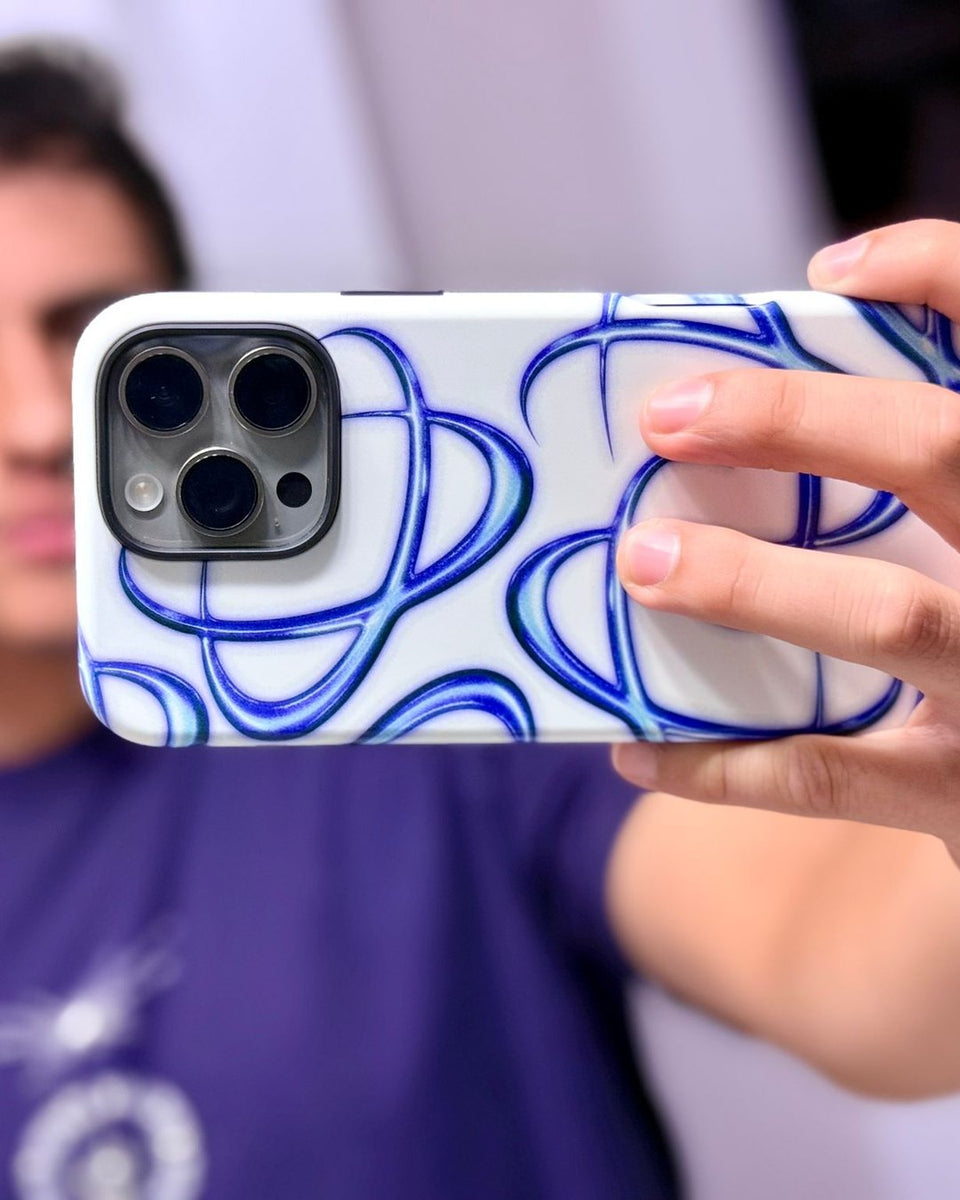 A customer holds up an iPhone in the Vitium case, white with blue and violet chrome loops